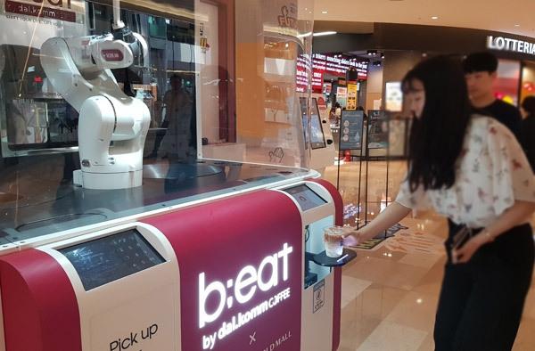  지난 4일 오후 서울 잠실 롯데월드몰을 찾은 방문객들이 건물 3층에 위치한 로봇카페 ‘비트’를 이용하고 있다. ‘비트’는 로봇 바리스타가 커피를 제조하는 이색 무인 카페다.