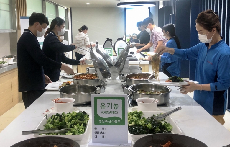 에코프라이데이 캠페인을 진행 중인 한국식품산업클러스터진흥원 임직원들이 친환경식재료로 구성된 음식을 담고 있다. [사진=친환경농산물자조금]