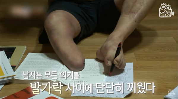 ◇ 왼쪽 발가락으로 펜을 쥐고 공부하는 이범식씨의 모습    *출처=유튜브 채널 '우와한 비디오'