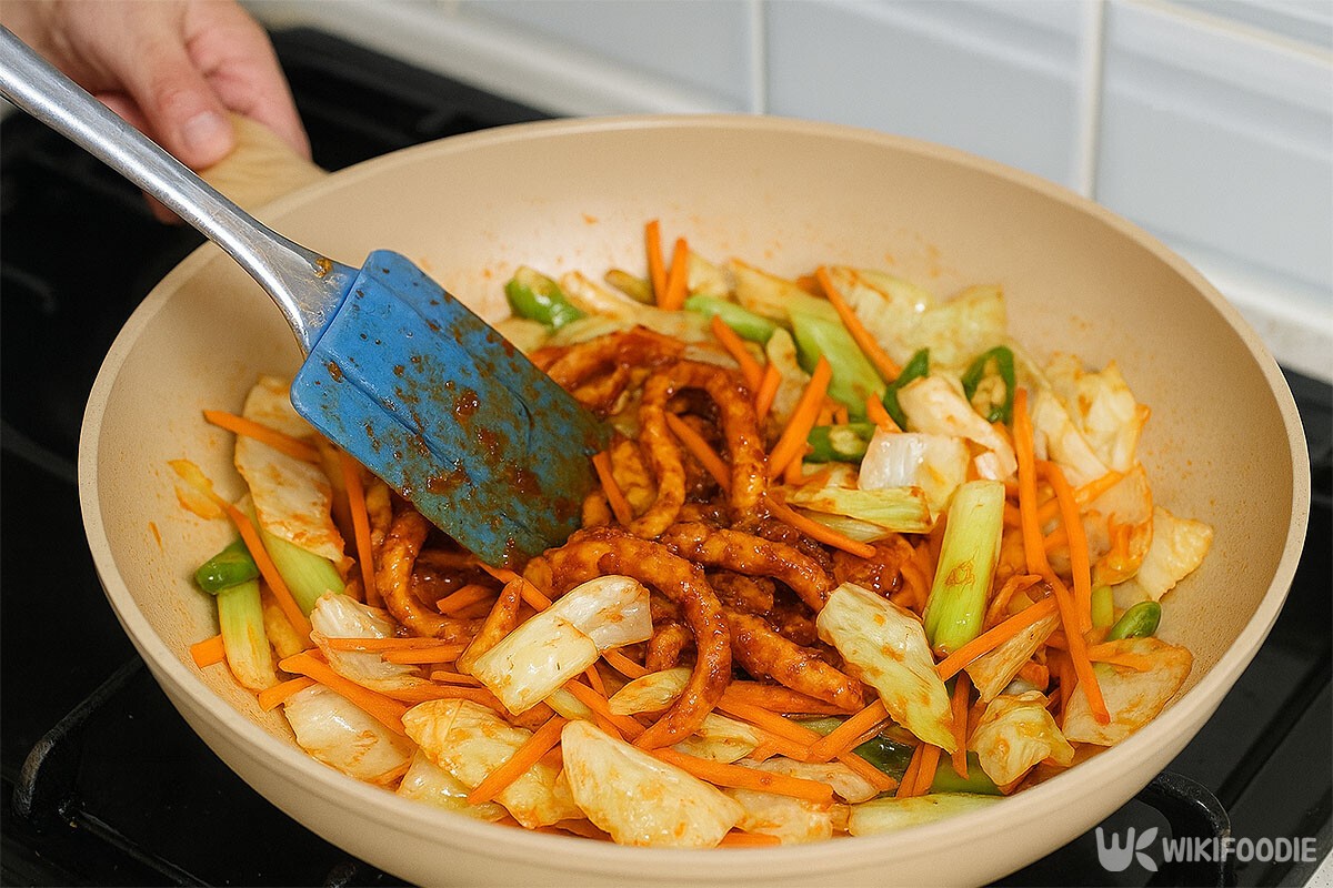채소들을 볶다가 양념 된 오징어를 넣고 있다. / 위키푸디